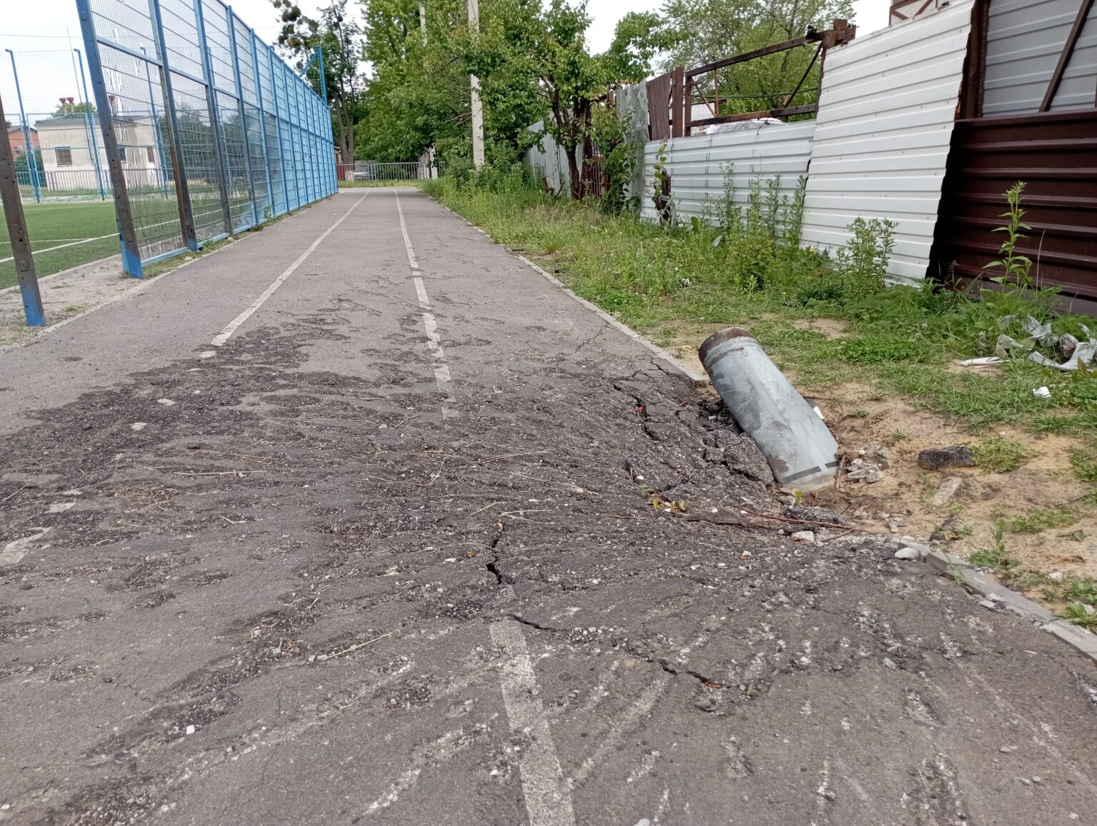 Remnants from an air-delivered bomb which hit the running track around a Kkarkiv school playground.